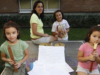 Estíbaliz Garrido y sus tres hijas, junto a su casa de Vallecas. Las dos mayores y ella misma son alumnas de una escuela municipal de música.