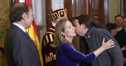Ana Pastor y Pablo Iglesias se saludan ante Pío Garcia-Escudero.