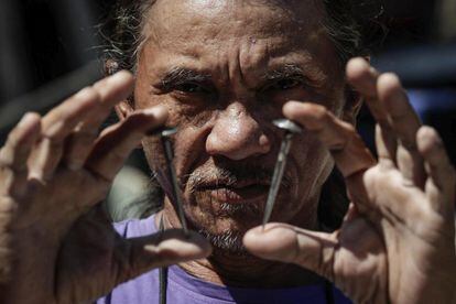 Rubén Enaje, un penitente filipino, muestra dos clavos que se utilizarán para sujetarlo a una cruz durante el Jueves Santo, en la localidad de San Fernando (Filipinas).