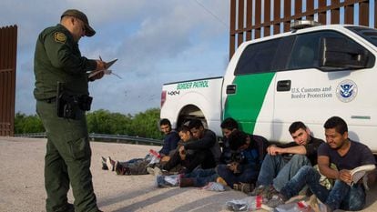 Un agente de la Patrulla Fronteriza detiene a un grupo de inmigrantes ilegales en la frontera entre México y Estados Unidos.
