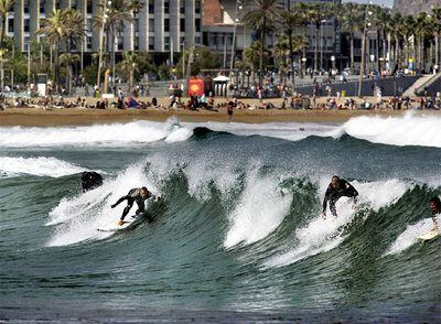 Varios surfistas practicando su deporte en la Barceloneta.