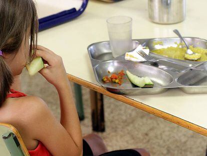 Una ni&ntilde;a almuerza en un comedor escolar