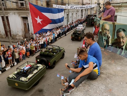 Cubanos presencian desde su azotea el paso de los restos del. expresidente Fidel Castro, en Santa Clara, Cuba, en diciembre de 2016.