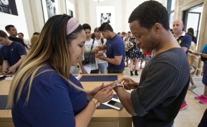 Una empleada de una de las tiendas de Apple en Nueva York prueba el reloj con un cliente.