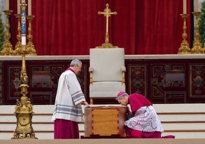 El arzobispo Georg Ganswein presenta sus respetos al féretro del papa, instalado en la plaza de San Pedro, en el Vaticano, lo que permite a los miles de fieles que aguardan fuera del templo rezar el rosario y despedir al papa difunto.