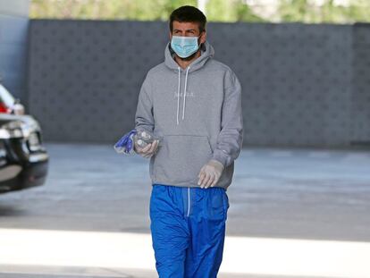 Pique accede a la ciudad deportiva del Barcelona con guantes y mascarilla.