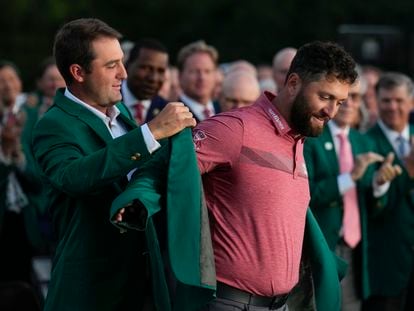 Scottie Scheffler pone la chaqueta verde del Masters de Augusta a Jon Rahm, este domingo.