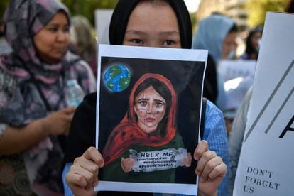 Una joven sostiene una pancarta durante una manifestación de miembros de la comunidad afgana frente a la embajada de Estados Unidos en Atenas.
