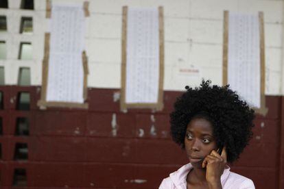 Una trabajadora electoral habla por teléfono a las puertas de un colegio electoral de Monrovia.