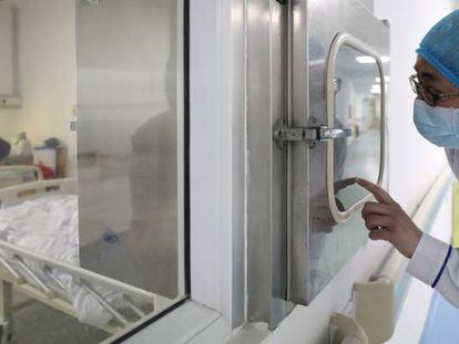 Un trabajador sanitario llama a un compañero dentro de un centro hospitalario de aislamiento para enfermos del coronavirus, en laJinyintan, en la provincia china de Wuhan.