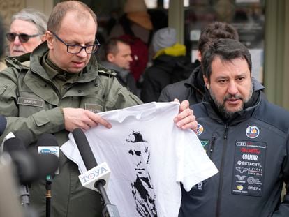 El alcalde de Przemysl, Wojciech Bakun, sostiene una camiseta con la imagen del presidente ruso, Vladímir Putin, mientras el italiano Matteo Salvini habla con los periodistas fuera de la estación de tren en Przemysl (Polonia), este martes.