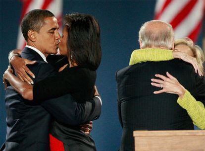 Obama besa a su mujer, Michelle, mientras su vicepresidente, Joe Biden, abraza a la suya, Jill, durante el acto de celebración se su victoria en Chicago.