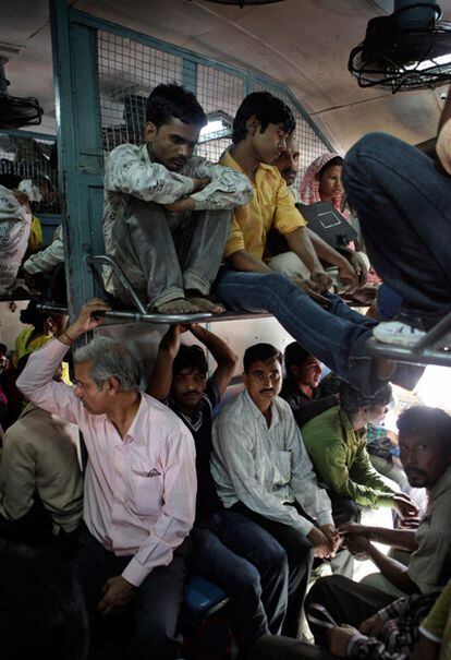 Varios hombres viajan en un tren camino de Nueva Delhi (India).