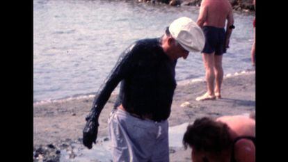 Un hombre se da un baño de barro en La Manga del Mar Menor.