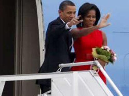 El presidente estadounidense, Barack Obama, y su esposa, Michelle, saludan antes de subir a bordo del Air Force One y emprender su viaje a Italia