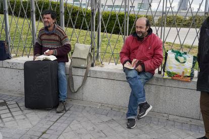 Antonio, el filósofo (izquierda), lee a Stevenson, Carlos a Grisham, mientras esperan que se abra el nuevo albergue de Ifema