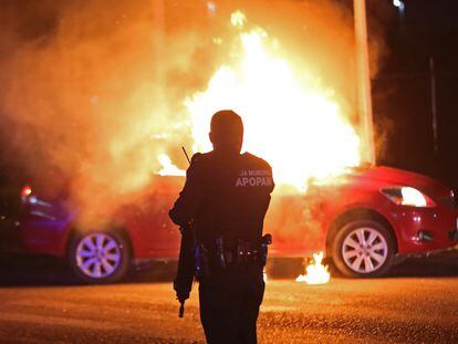 Un policía municipal de Zapopan acude al lugar donde grupos delincuenciales habían incendiado un vehículo, en el Estado de Jalisco, el 9 de agosto de 2022.
