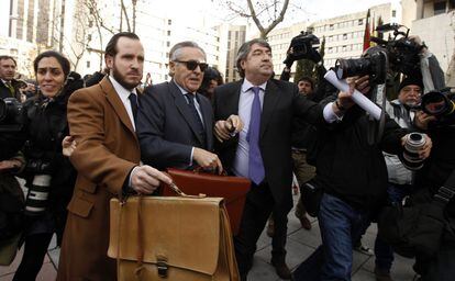 Los abogados de Miguel Blesa le rodean para evitar el enfrentamiento con un grupo de personas que lo esperaban en el exterior de los juzgados de Plaza Castilla, 24 de enero de 2014.