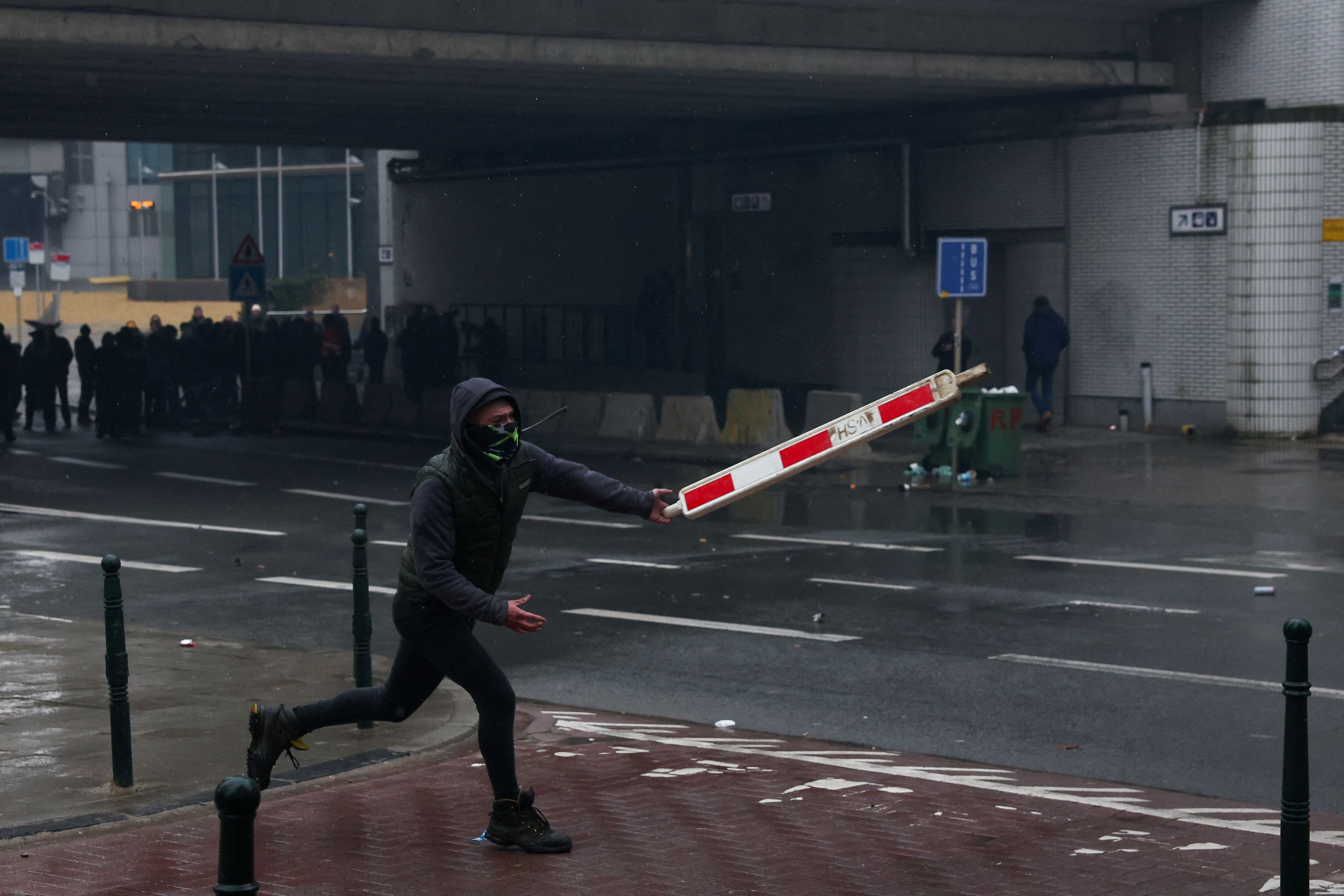 Un hombre lazan un objeto durante la protesta de agricultores, este lunes en Bruselas. 