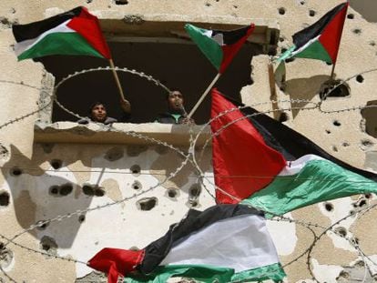 Dos j&oacute;venes ondean banderas palestinas en Rafah (Gaza) en una protesta para pedir a Egipto que suministre electricidad y combustible a la Franja.
