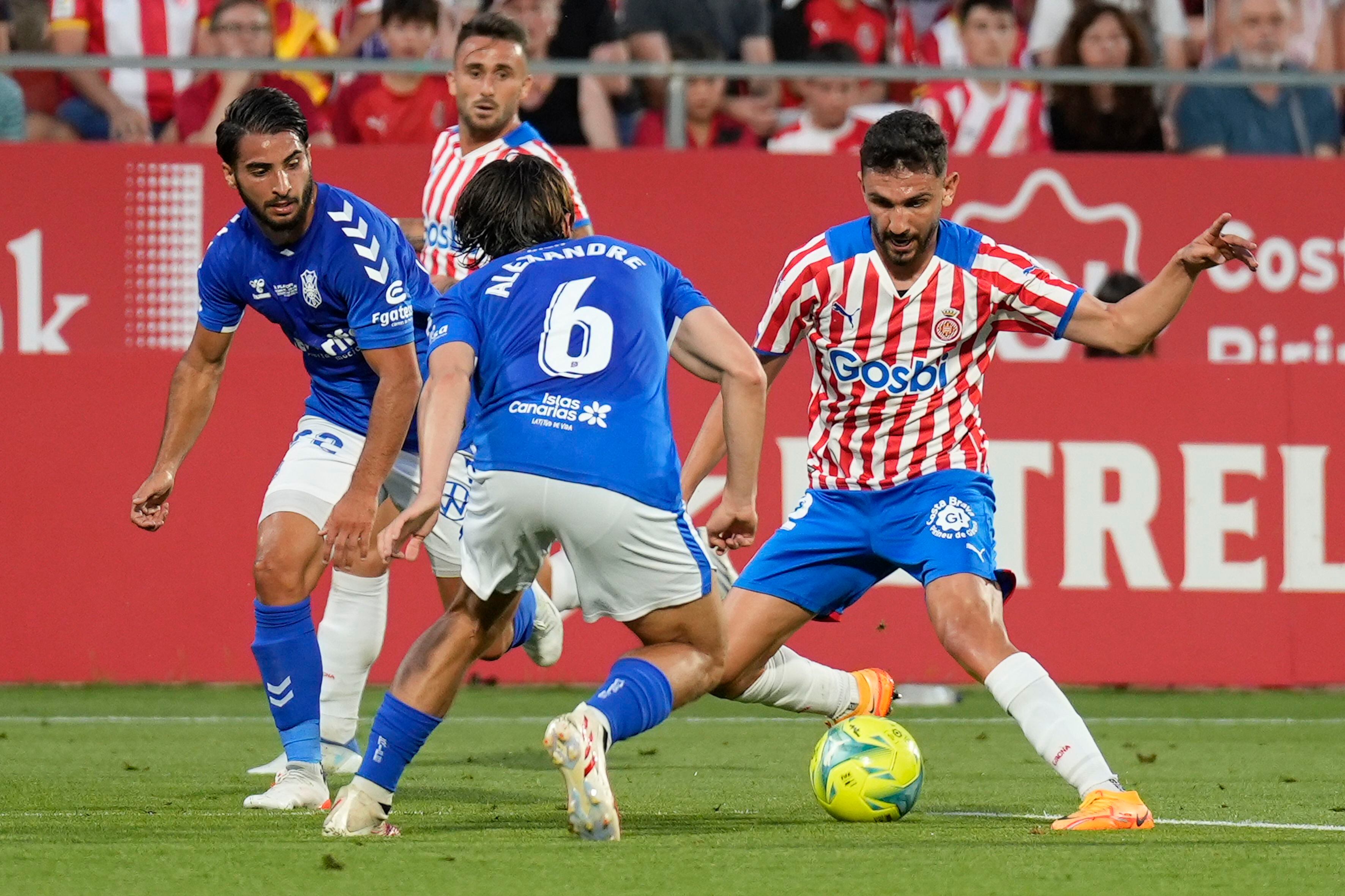 El centrocampista del Girona Iván Martín (derecha) juega un balón ante Alexandre Corredera, del Tenerife, durante el partido de ida de la final de ascenso a LaLiga Santander disputado el 11 de junio en el Estadio de Montilivi, en Girona.