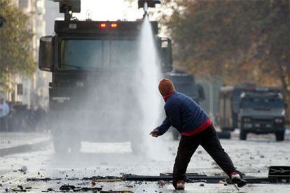 Estudiantes chilenos huyen de un cañón de agua de la policía en Santiago