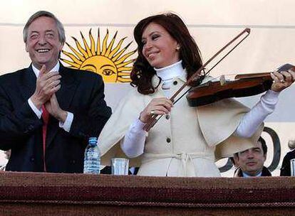 Néstor Kirchner aplaude mientras su esposa, Cristina Fernández, simula tocar un violín el jueves en un acto en Santiago del Estero (noroeste de Argentina).
