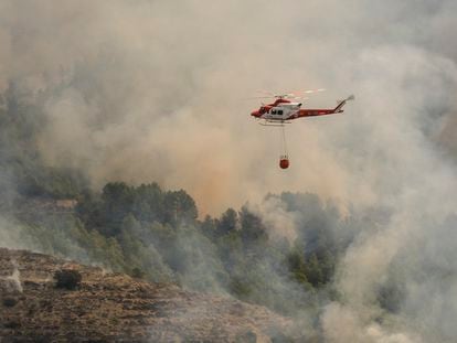 Un helicóptero de los Servicios de Emergencia trabaja en la extinción del incendio forestal de Tàrbena, este lunes.
