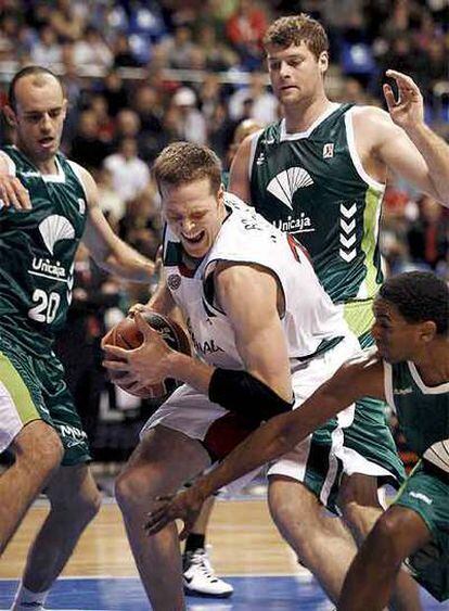 El jugador del Granada Borchardt trata de zafarse de los jugadores del Unicaja