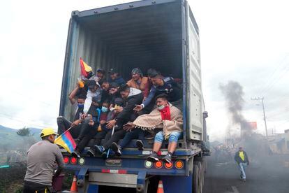 Un grupo de manifestantes que viajan en la parte trasera de un camión reciben bebidas y alimentos a su llegada a Quito.