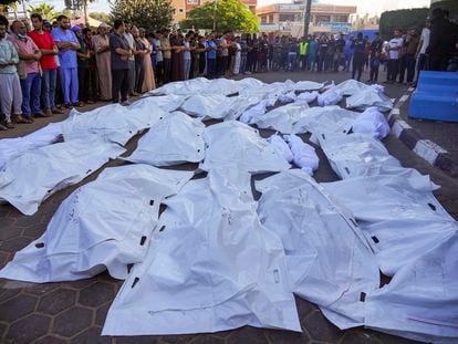 Un grupo de palestinos ante los cuerpos de sus familiares asesinados por un bombardeo israelí en la ciudad de Deir al Balah, en el centro de la franja de Gaza, este lunes.