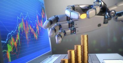 Una mano robótica apila monedas sobre el teclado de un ordenador portátil en cuya pantalla aparece una gráfica ascendente.