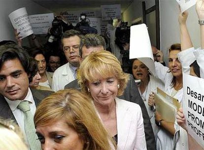 Aguirre y Güemes pasan junto a unas trabajadoras con carteles contra la privatización de la Sanidad pública.