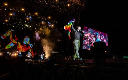 Dan Reynolds, líder de Imagine Dragons, con una bandera arcoíris que le lazaron desde el público.