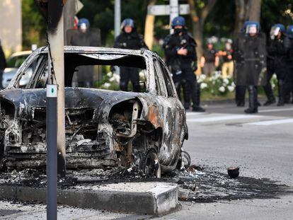 Gendarmes junto a un coche incendiado en el barrio Gresilles de Dijon, centro de los disturbios del fin de semana.
