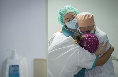 Tres enfermeras se abrazan por el traslado a planta del último paciente ingresado en la Unidad de Cuidados Intensivos con coronavirus del hospital Quirónsalud Sagrado Corazón de Sevilla.