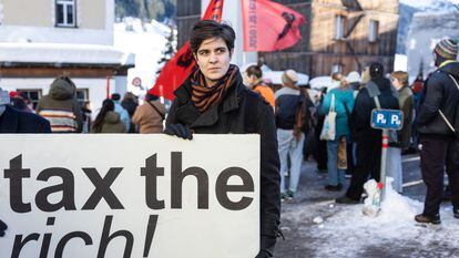 La heredera millonaria y activista social germano-austriaca Marlene Engelhorn sostiene un cartel que dice '¡impongan impuestos a los ricos!' durante la celebración del foro de Davos, el 14 de enero.