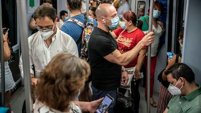 Decenas de pasajeros, en agosto de 2020 en los vagones de uno de los trenes que recorre la linea 10 del metro de Madrid.