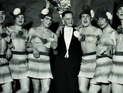 Hombre en esmoquin rodeado de seis travestis. Alemania, invierno de 1937.