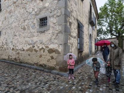 Una família passeja pel centre d'Òrrius, al Maresme.