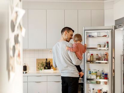 Un hombre con su hija en la cocina.