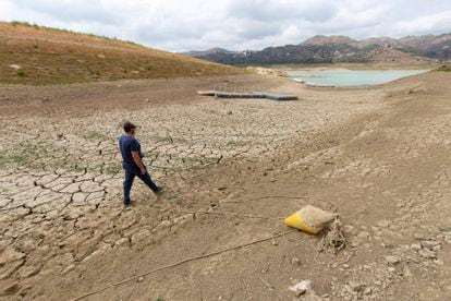 La reserva de agua cae al 39%, el menor porcentaje desde la gran sequía de 1995. En la imagen, un hombre camina el martes por el pantano de La Viñuela (Málaga), que se encuentra al 12% de su capacidad y que si la lluvia no lo remedia puede ser declarado embalse muerto.