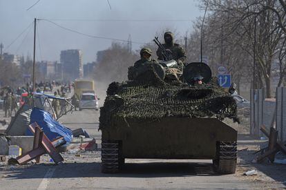 Pro-Russian troops in uniforms without insignia drove an armored vehicle through Mariupol on Saturday.