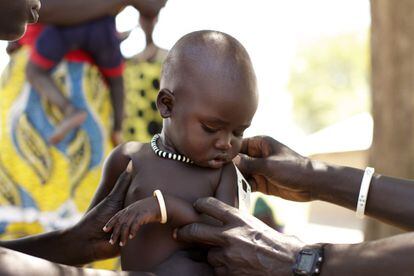 La madre de esta niña explica que la pequeña acaba de recuperarse de la malaria aunque su aspecto, según los especialistas que le colocan la cinta, es saludable.