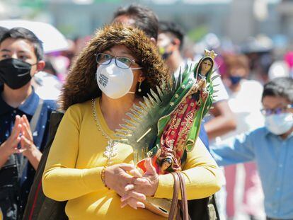Una mujer con cubrebocas sostiene una figura de la Virgen de Guadalupe el sábado pasado.