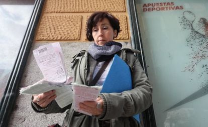 Susana Fonseca, madre de un hijo ludópata desde hace 10 años posando con las últimas apuestas de su hijo en un local de Lavapiés.