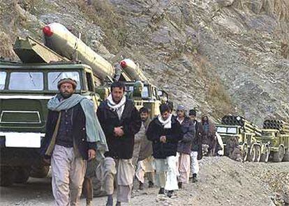 Un grupo de afganos camina junto a una columna de vehículos militares ayer cerca de Kabul.