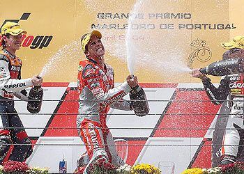 Toni Elías celebra su victoria en los 250cc del Gran Premio de Portugal, en Estoril, entre el argentino Sebastián Porto (a su derecha) y el francés Randy de Puniet.