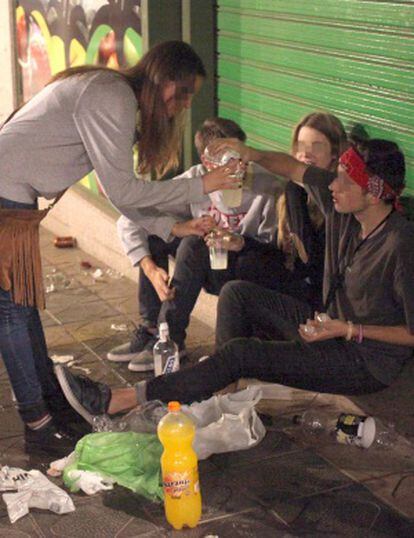 Cuatro j&oacute;venes beben alcohol en la calle en Tarragona.