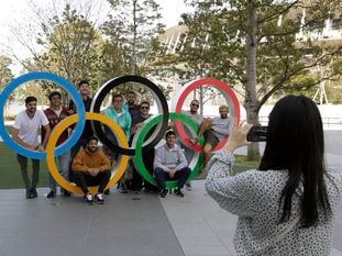 Un grupo de estudiantes uruguayos posan junto a los anillos olímpicos en las afueras del estadio de Tokio (Japón).